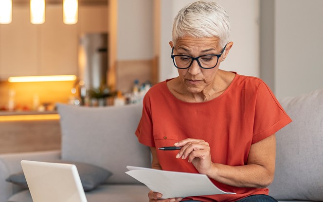 Woman Using A Laptop And Checking Finances At Home