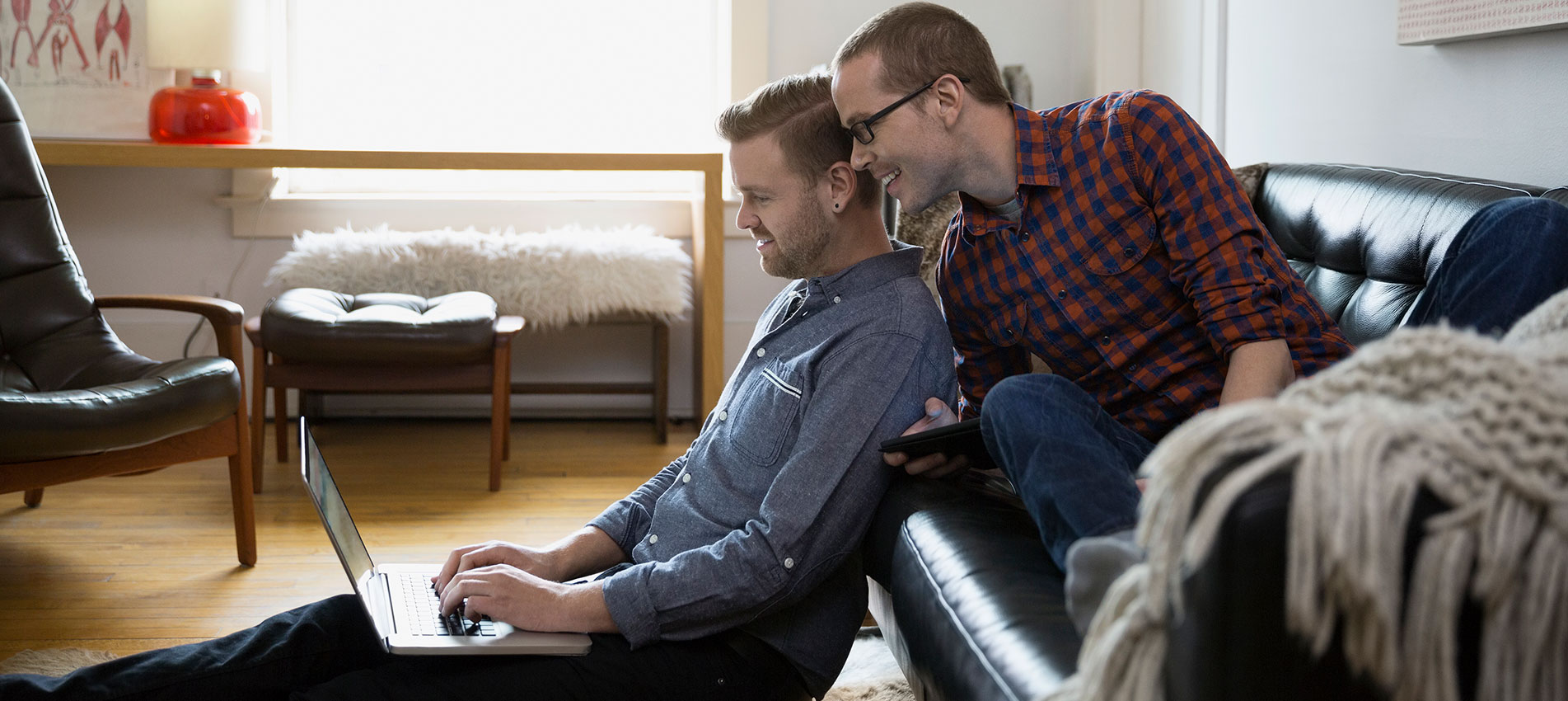 Couple Using Laptop In Living Room