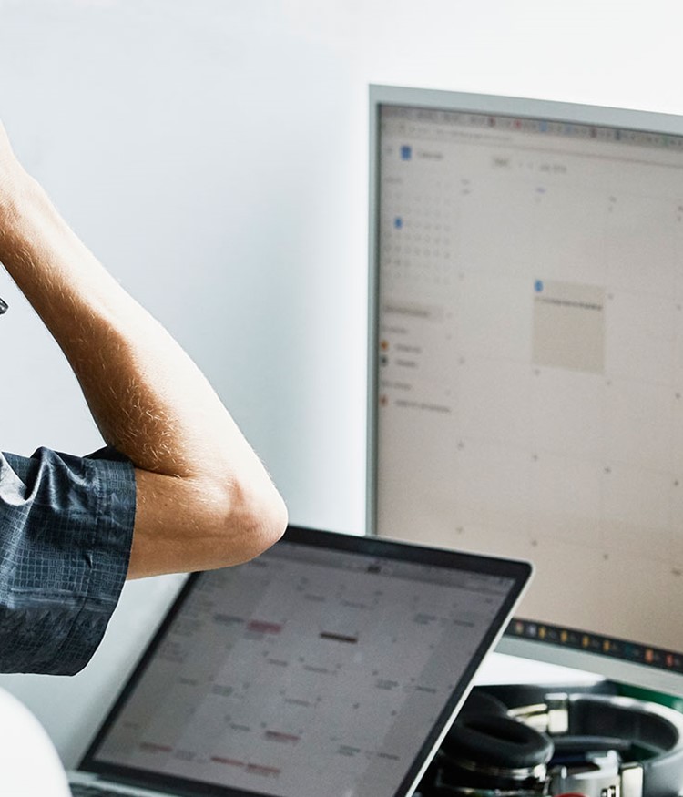 Man Scratching Head While Looking At Calendar On Computer Monitor