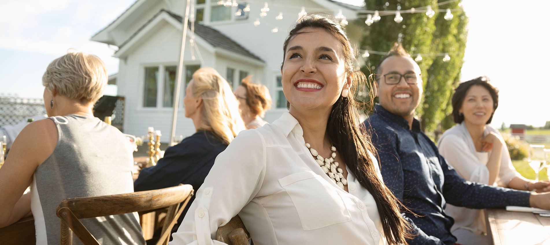 Smiling Woman Enjoying Garden Party At Sunny Patio Table