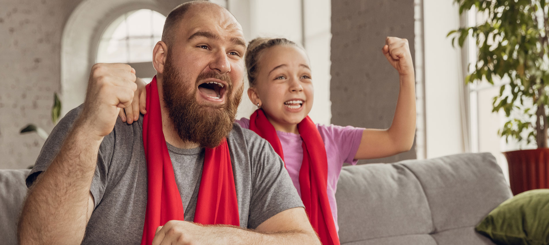 Excited, Happy Daughter And Father Watch Sports Together On The Couch