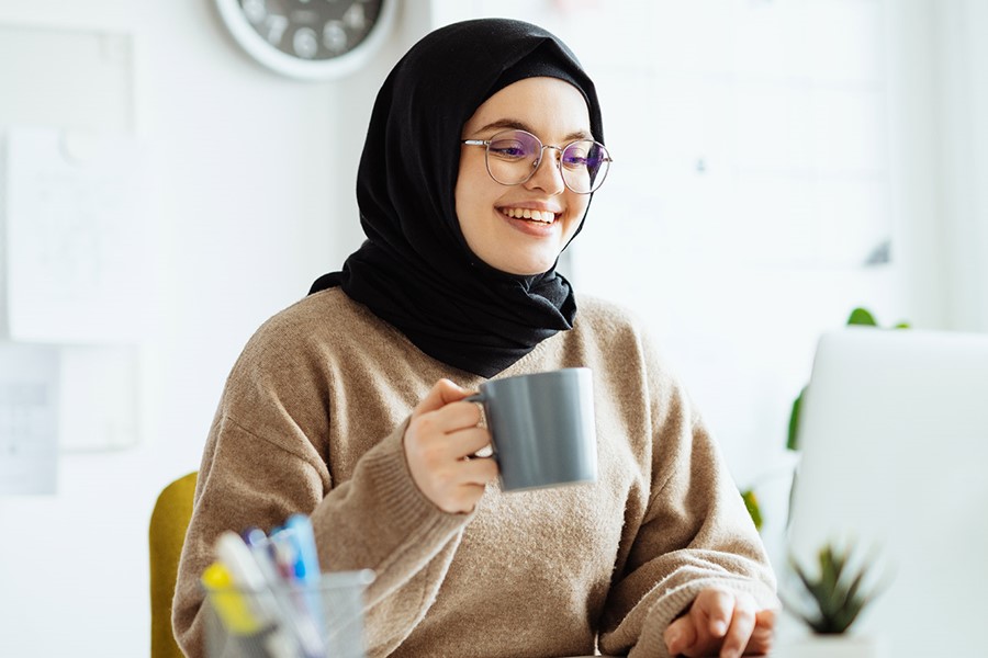 Middle Eastern Woman With Hijab And Glasses Working On Laptop