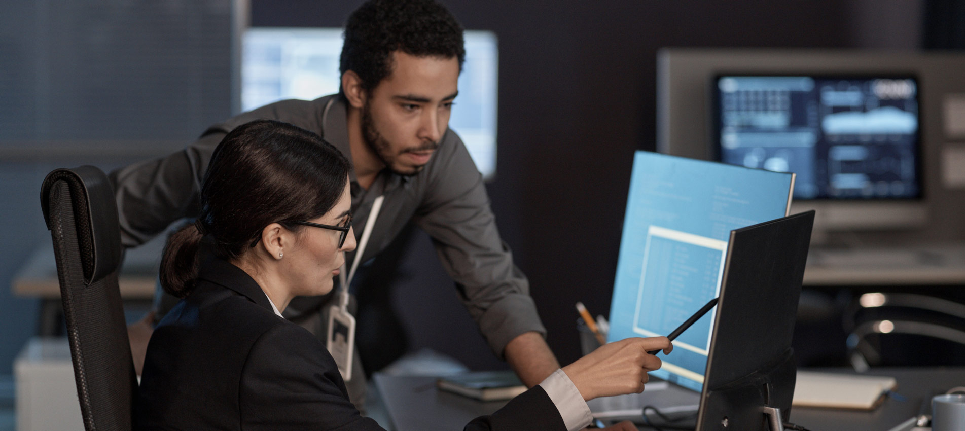Two People Pointing At Computer Screen While Working In IT Company