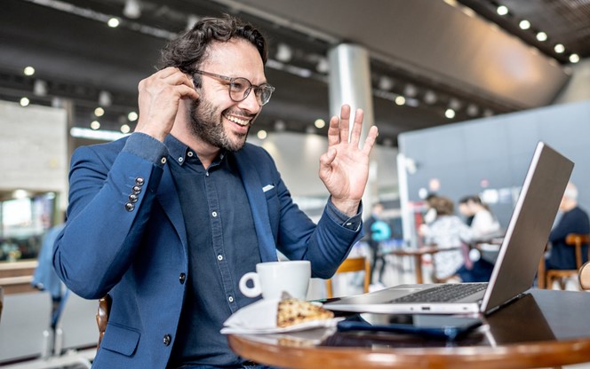 Businessman Doing A Video Call Using Laptop In Coffee Shop At Airport