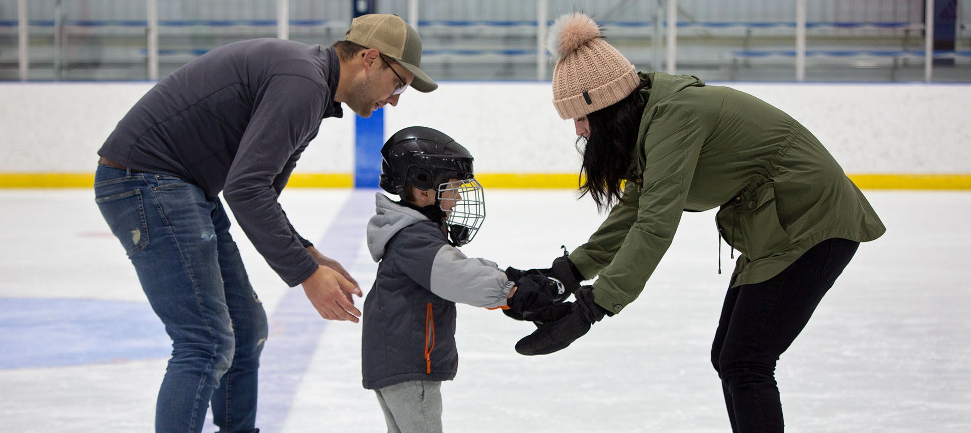 Mom And Dad Encourage Little Son To Ice Skate
