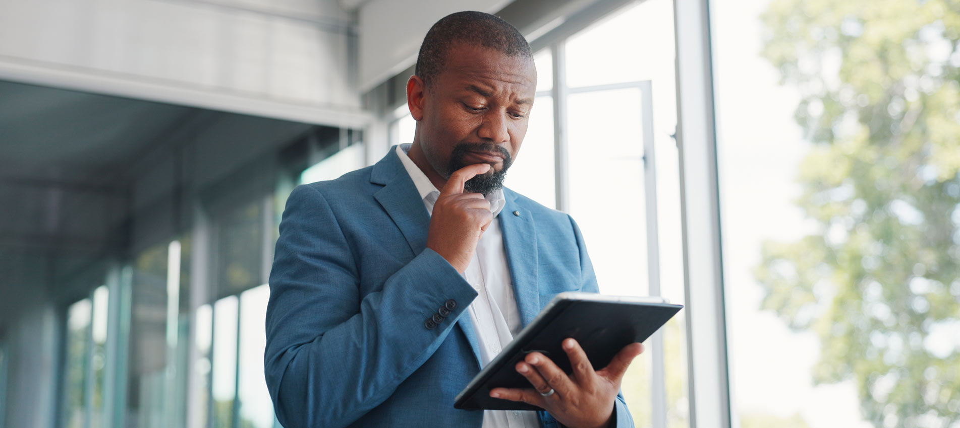 Business Man Looking At Tablet And Thinking Of Stock Market Decision